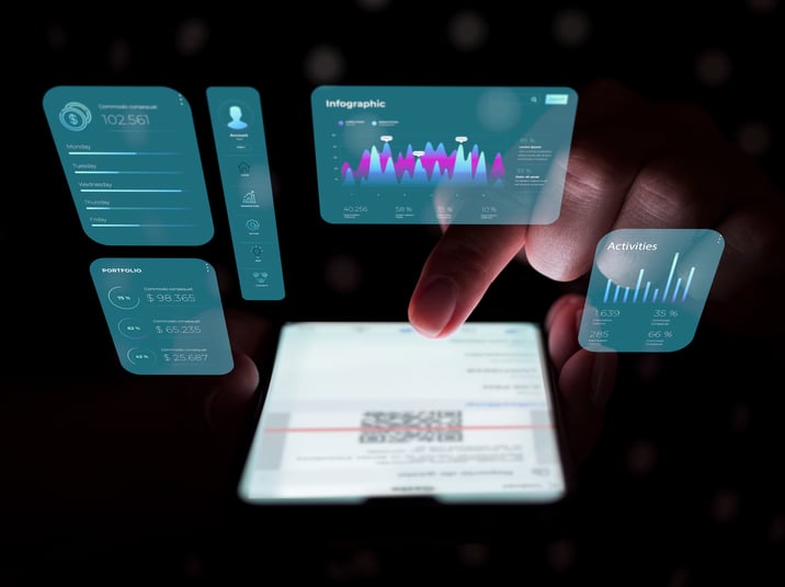 Mano sosteniendo un dispositivo con interfaces de datos financieros flotantes en el aire, mostrando estadísticas diversas como cartera, ingresos y actividades, ilustrando conceptos de tecnología futurista en finanzas