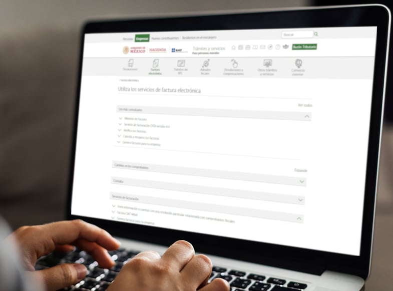 ersona utilizando una computadora portátil para acceder a la página web del SAT de México