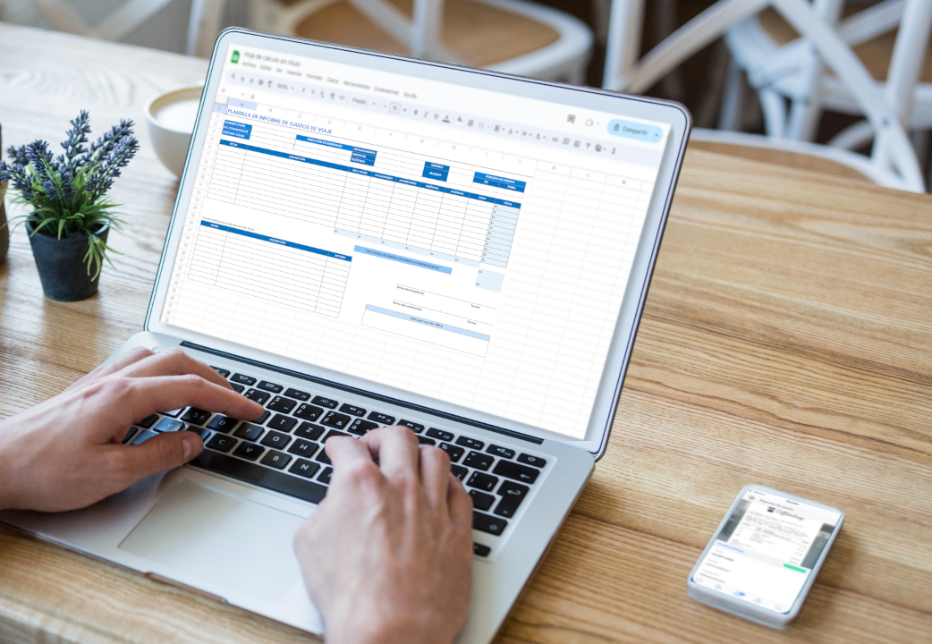  Una persona utiliza una laptop para trabajar en una hoja de cálculo titulada "Planilla de Informe de Gastos de Viaje." La hoja de cálculo tiene secciones para detallar distintos tipos de gastos. Al lado de la laptop, sobre la mesa de madera, hay un smartphone que también muestra una aplicación relacionada con la gestión de gastos, reforzando la conexión entre el uso de planillas y aplicaciones móviles para el control financiero.