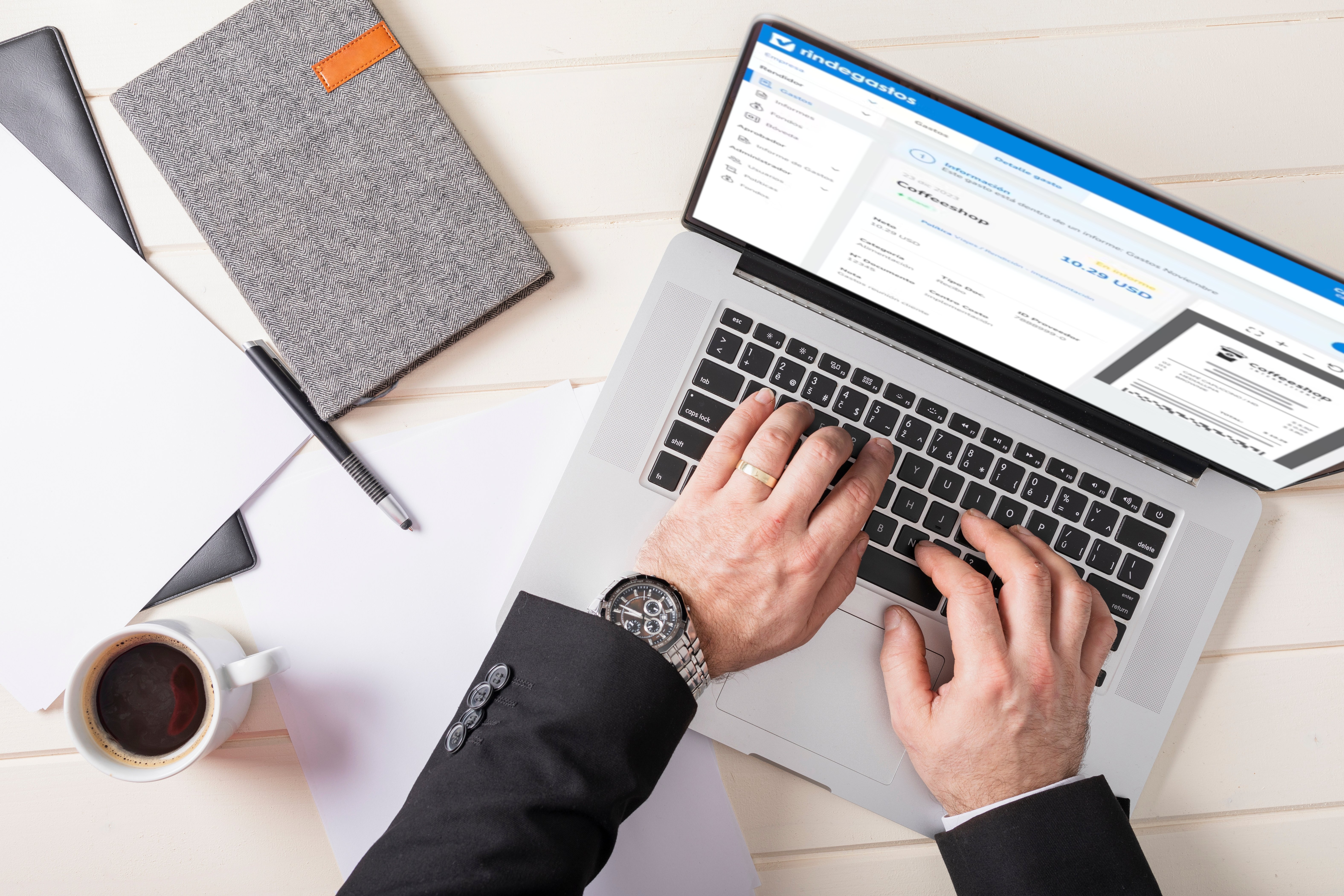 Vista superior de una persona trabajando en una laptop con la plataforma Rindegastos abierta, mostrando el detalle de un gasto