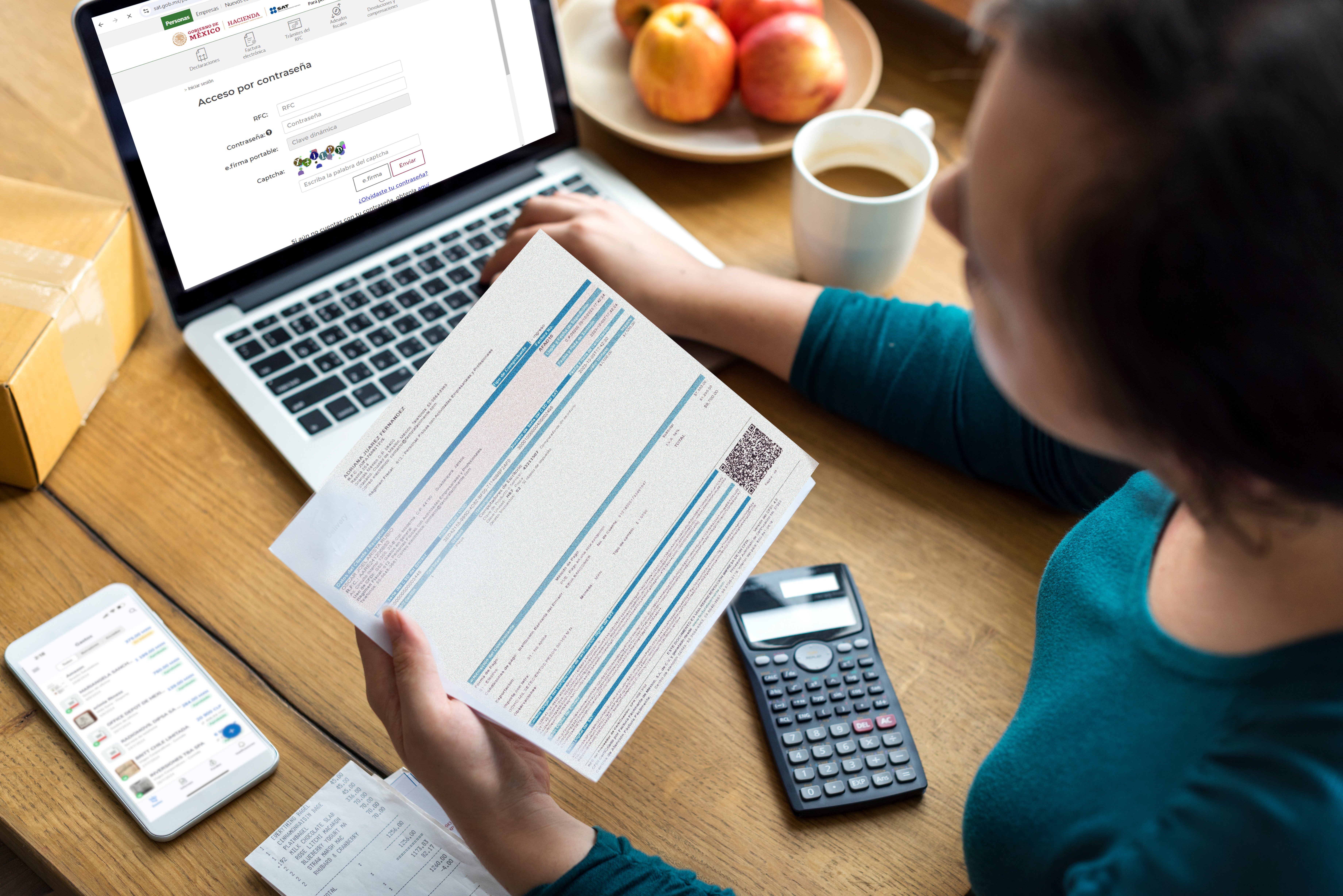 ujer sentada en su escritorio con una laptop abierta mostrando una página de acceso al SAT. Ella sostiene un documento impreso en sus manos mientras consulta detalles. Sobre la mesa, hay una calculadora, una taza de café, y un plato con manzanas, lo que sugiere un ambiente de trabajo